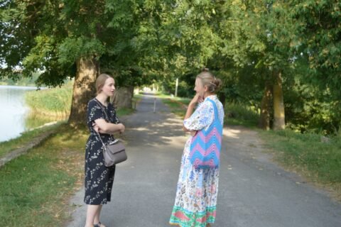Two women standing on a path talking